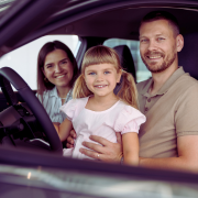 Happy family smiling in a car, representing reliable auto insurance in New Jersey from – The Barclay Group