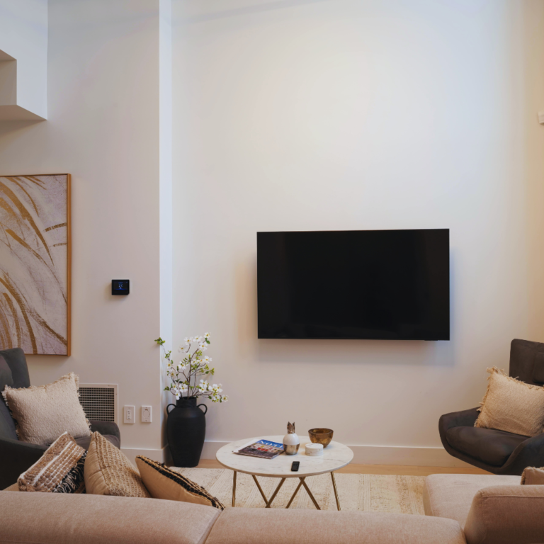 Modern minimalist NJ living room with wall-mounted TV representing home insurance coverage – The Barclay Group